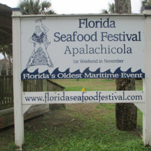 A wooden sign for the Florida Seafood Festival with a banner advertising "Florida's Oldest Maritime Event."