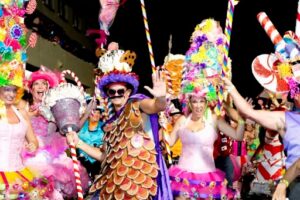 A group of attendants dressed in colorful attire dance at the Key West Fantasy Fest in Florida.