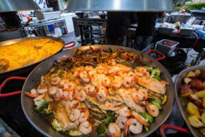 A large plate of fresh shrimp and sauteed vegetables available at the Pensacola Seafood Festival in Florida.
